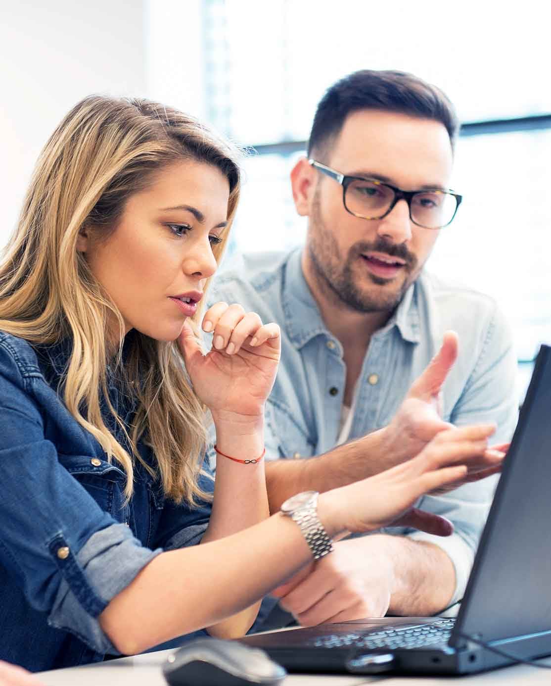Two RoZetta colleagues working through a problem together at a laptop